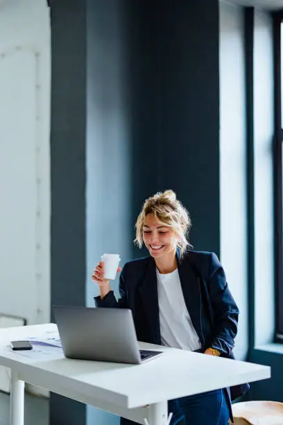 Business owner smiling while reviewing invoice funding options on her laptop