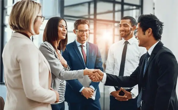 Business professionals shaking hands after agreeing on a staffing invoice funding solution