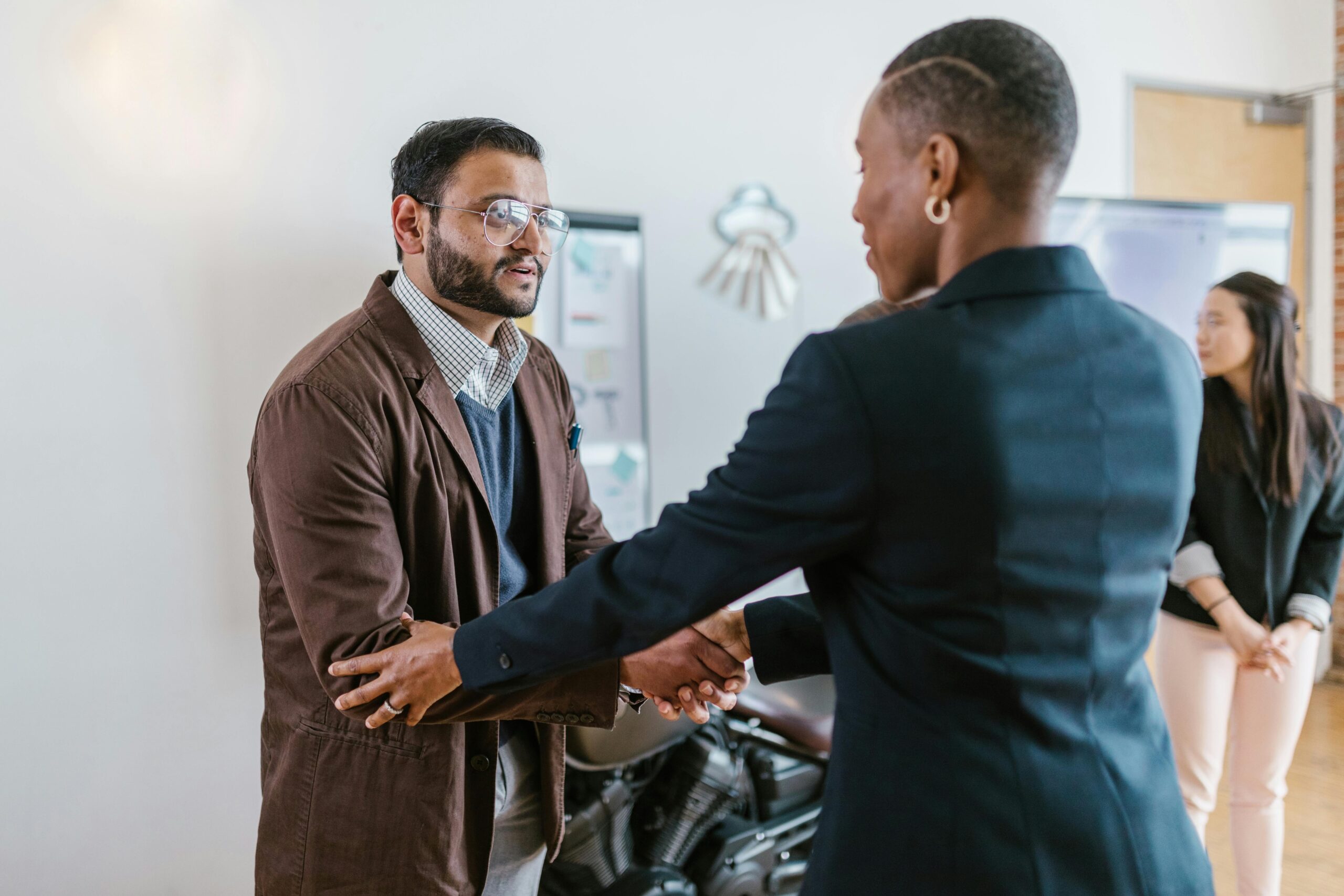 Business owner and funding provider shaking hands after agreeing on invoice funding solution