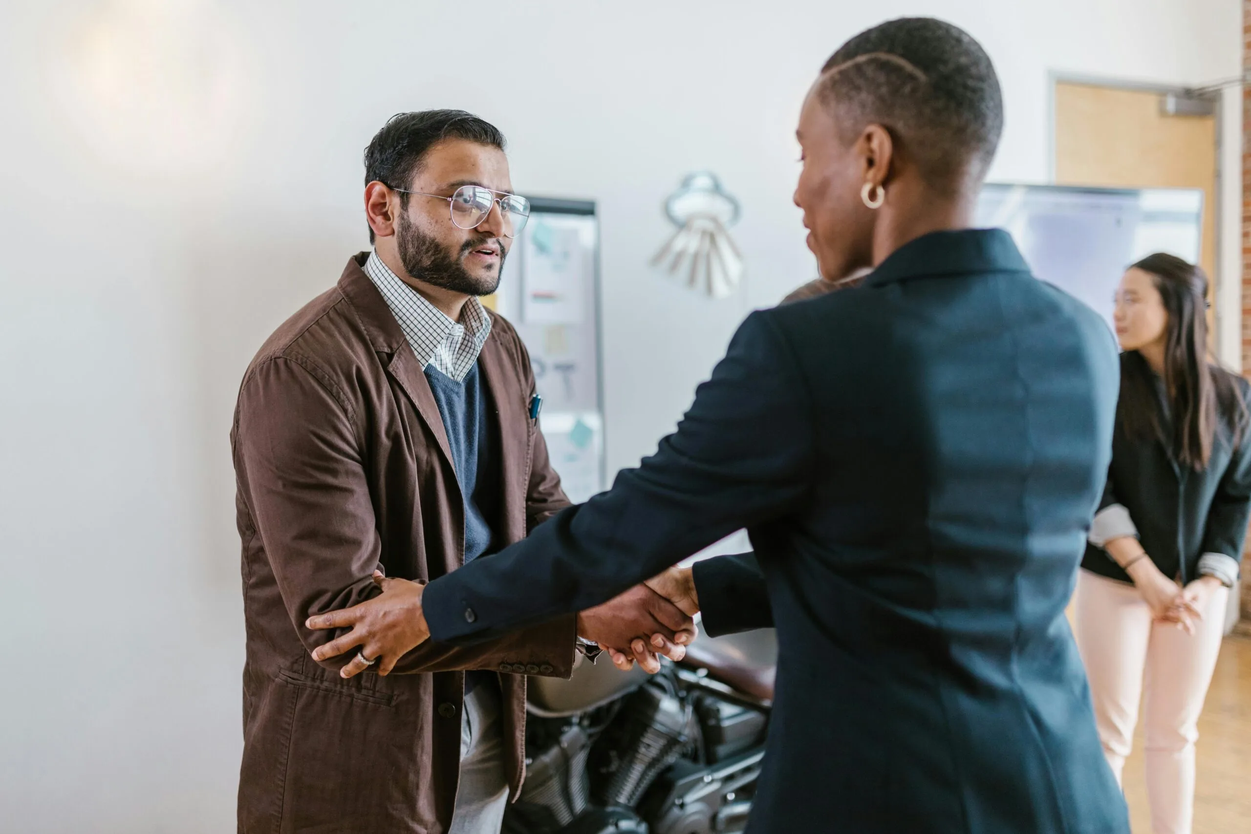 Business owner and funding provider shaking hands after agreeing on invoice factoring solution